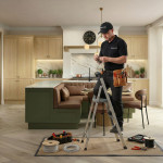 Mastercraft Kitchens electrician installing pendant lighting above a kitchen island within a bespoke fitted kitchen, part of the full design and installation service delivered by the Mastercraft team.