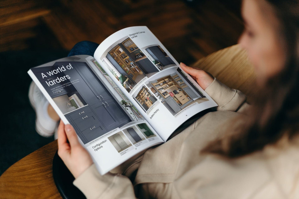 Mastercraft Kitchens Brochure A person browsing through a beautifully designed Mastercraft kitchen brochure, featuring high-quality images and layouts showcasing various kitchen styles and designs. The open pages highlight bespoke cabinetry and elegant finishes, inspiring readers to imagine their own dream kitchen. The setting conveys a sense of relaxation and focus, reflecting the thoughtful process of planning a tailored kitchen with Mastercraft Kitchens