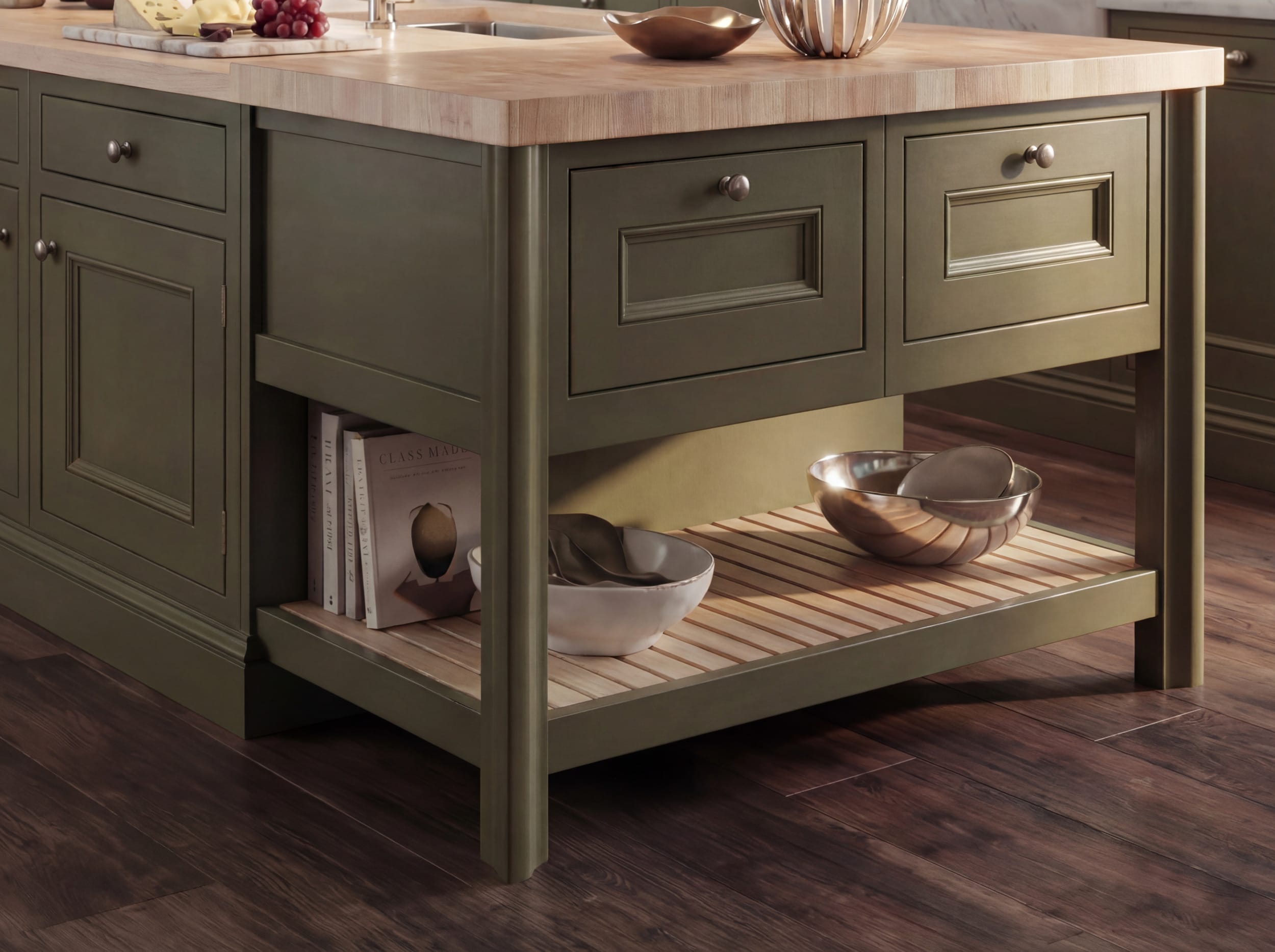 Mastercraft in-frame kitchen island in olive green with solid wood butcher’s block worktop, open slatted shelf, and traditional shaker drawer detailing over dark wood flooring
