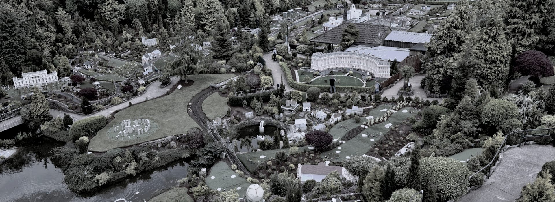 miniature village with model buildings, green lawns and winding paths