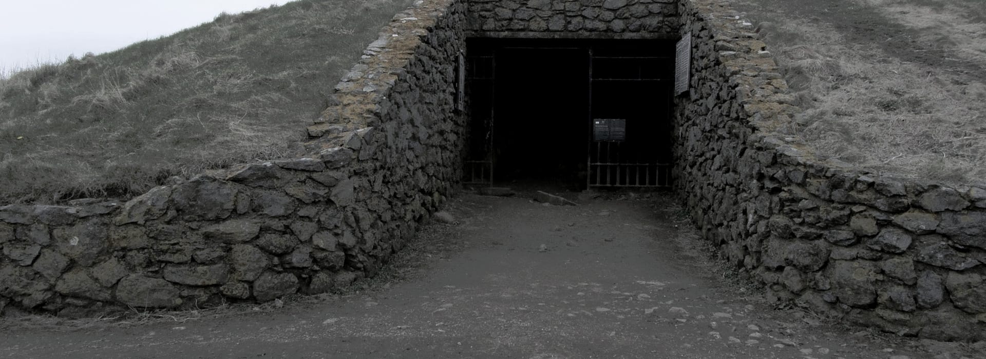 stone tunnel entrance built into grassy earth mound