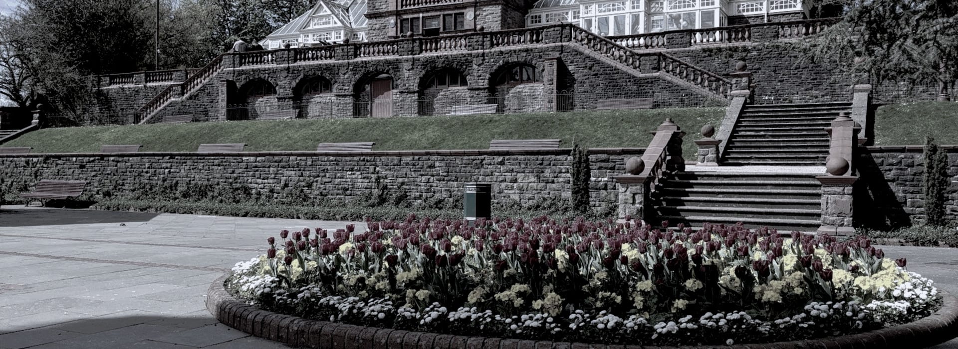 Bespoke Kitchens Bassaleg - Mastercraft Kitchens circular flower bed with dark red tulips in front of stone steps