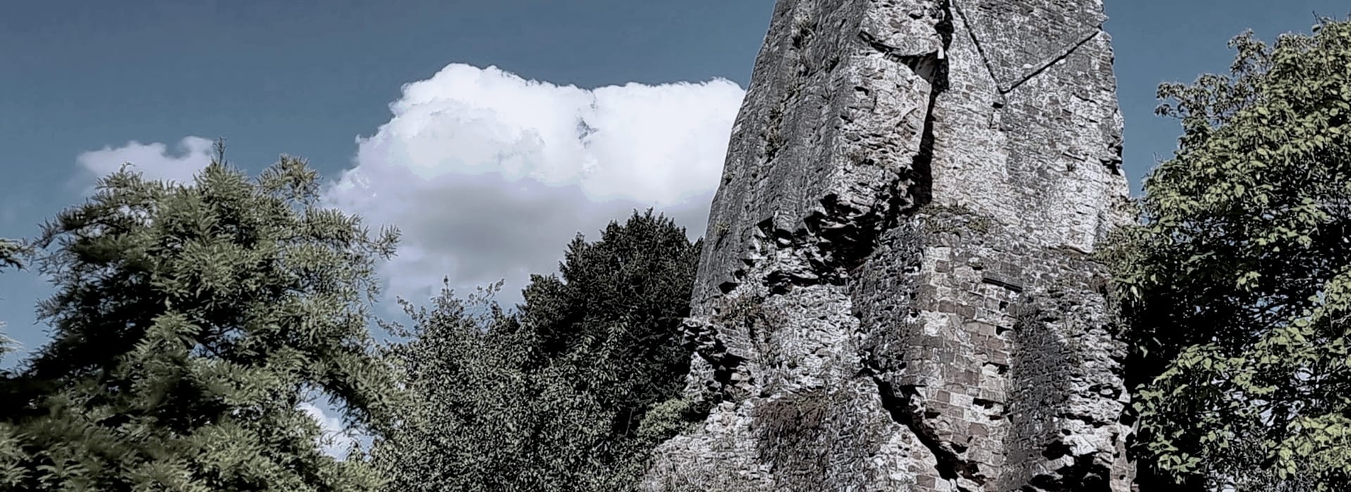 Bespoke Kitchens Bridgnorth - Mastercraft Kitchens weathered stone ruin surrounded by dense green foliage under a blue sky