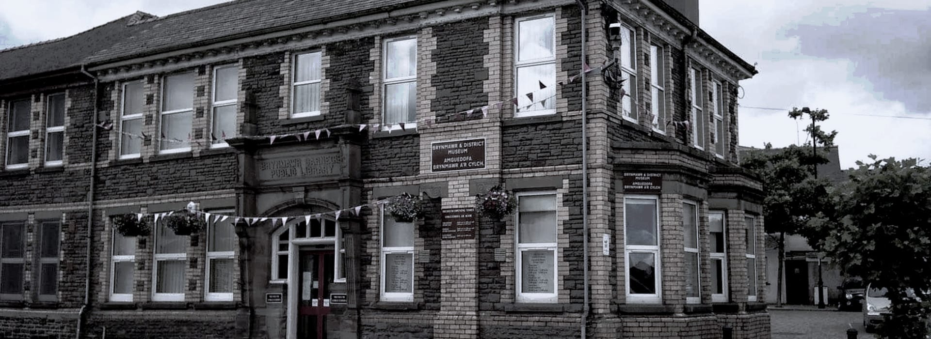 Victorian stone building with white-trimmed windows and bunting along the facade