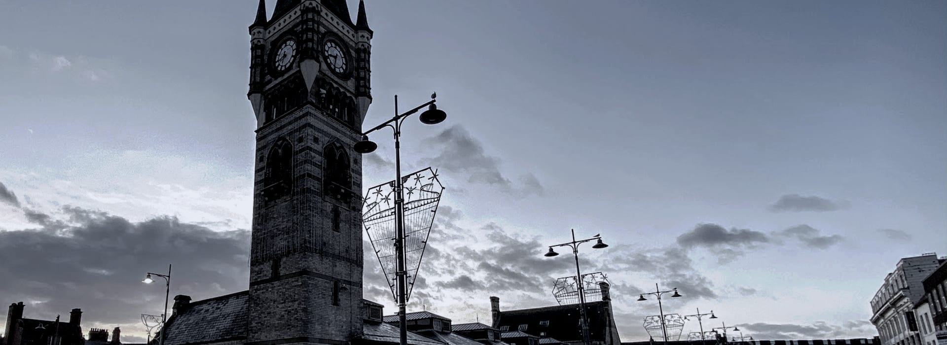 Bespoke Kitchens Darlington - Mastercraft Kitchens monochrome clock tower with pointed roof against cloudy evening sky