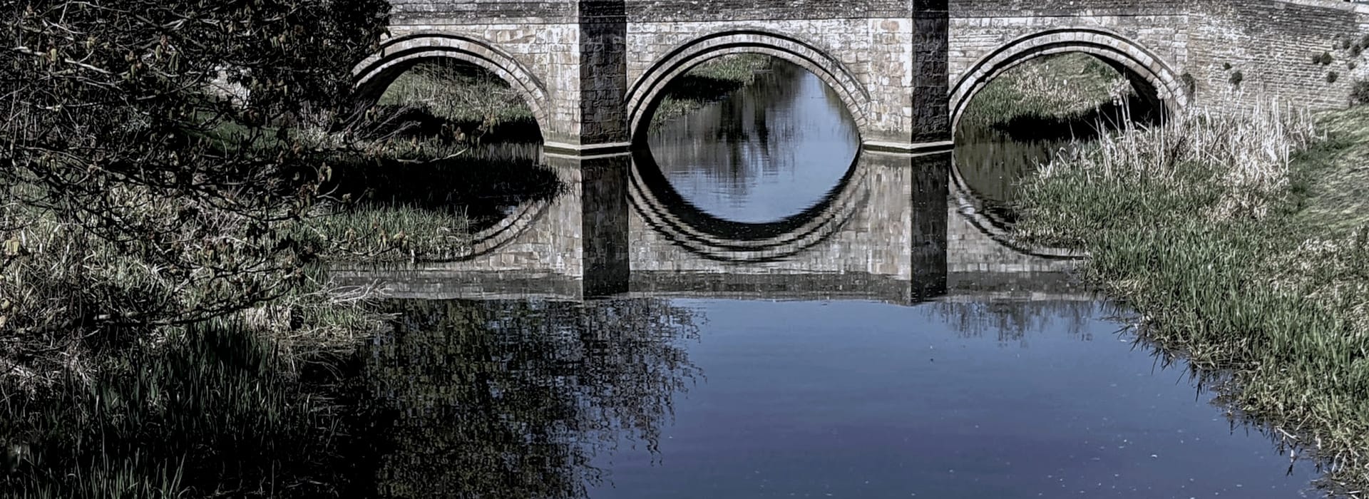 Bespoke Kitchens Market Deeping - Mastercraft Kitchens stone bridge with three arches reflected in calm blue water