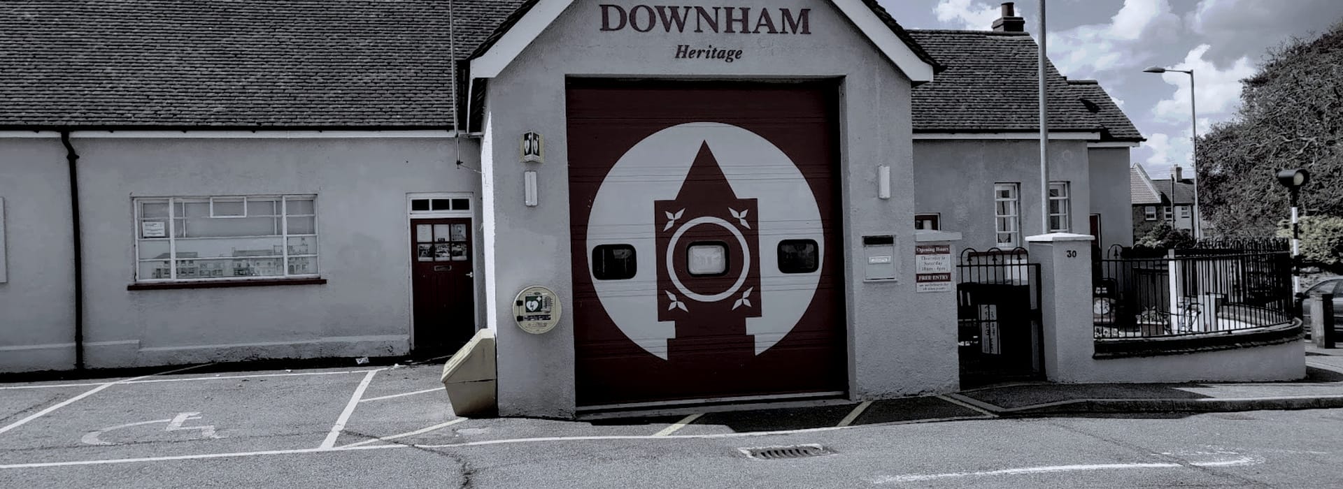 Bespoke Kitchens Downham Market - Mastercraft Kitchens grey building with maroon garage door featuring white geometric motif
