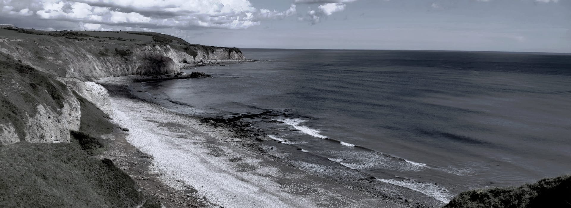 rocky coastline with white cliffs and calm grey-blue sea