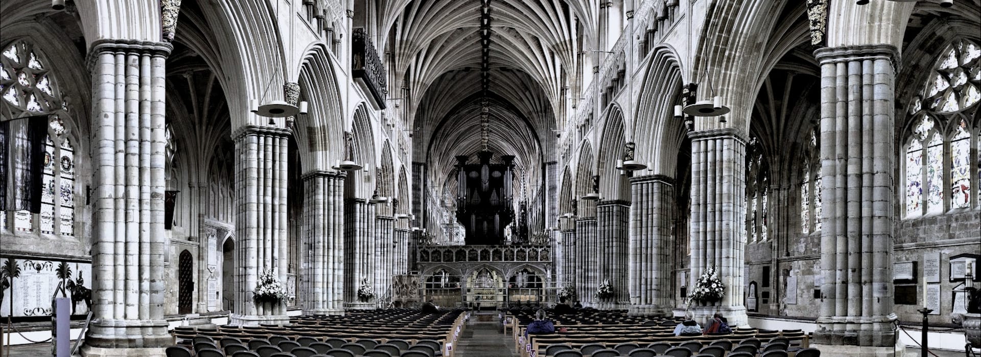 vaulted stone arches with tall columns and stained glass windows