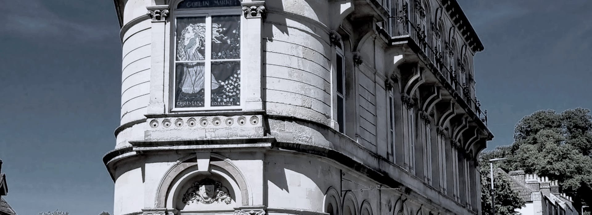 curved stone building with arched windows and decorative cornices