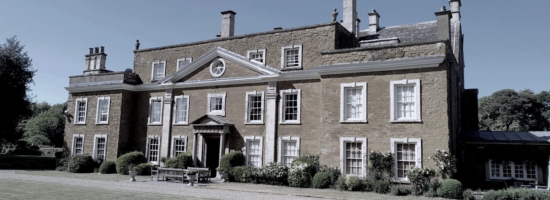 Bespoke Kitchens Melton Mowbray - Mastercraft Kitchens Georgian manor house with symmetrical windows and stone façade under clear sky