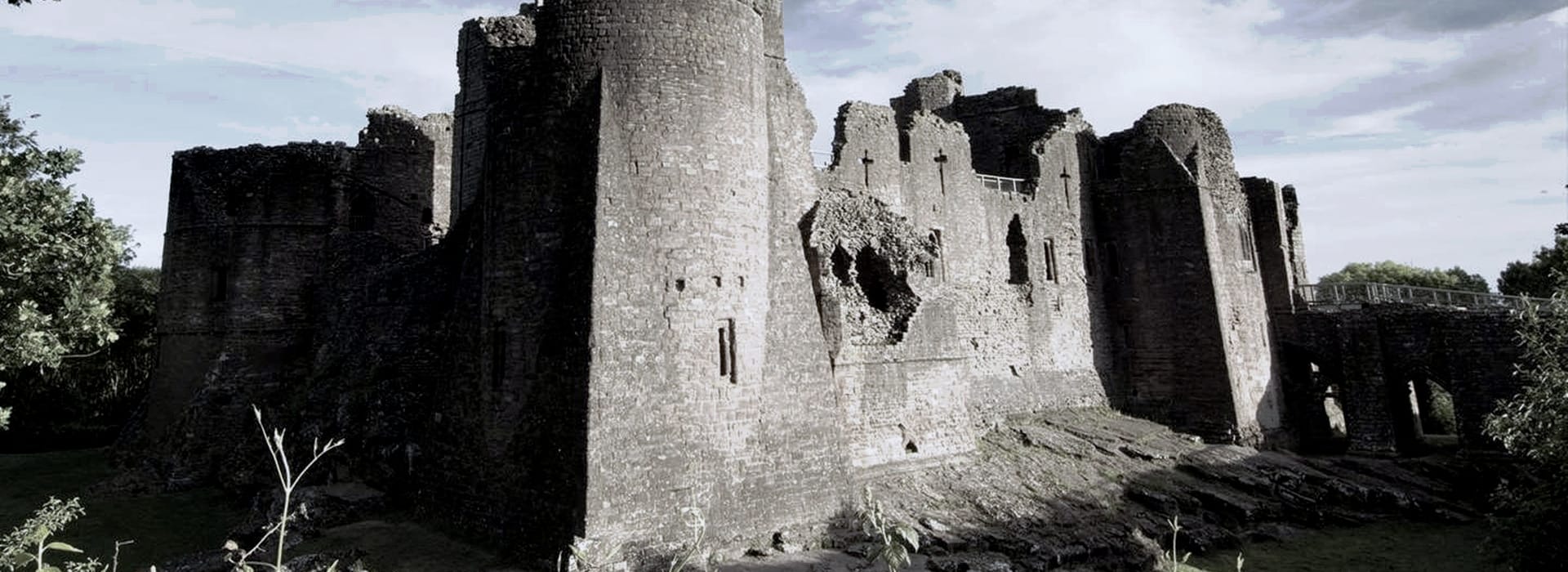 weathered stone castle ruins with large round towers and broken walls