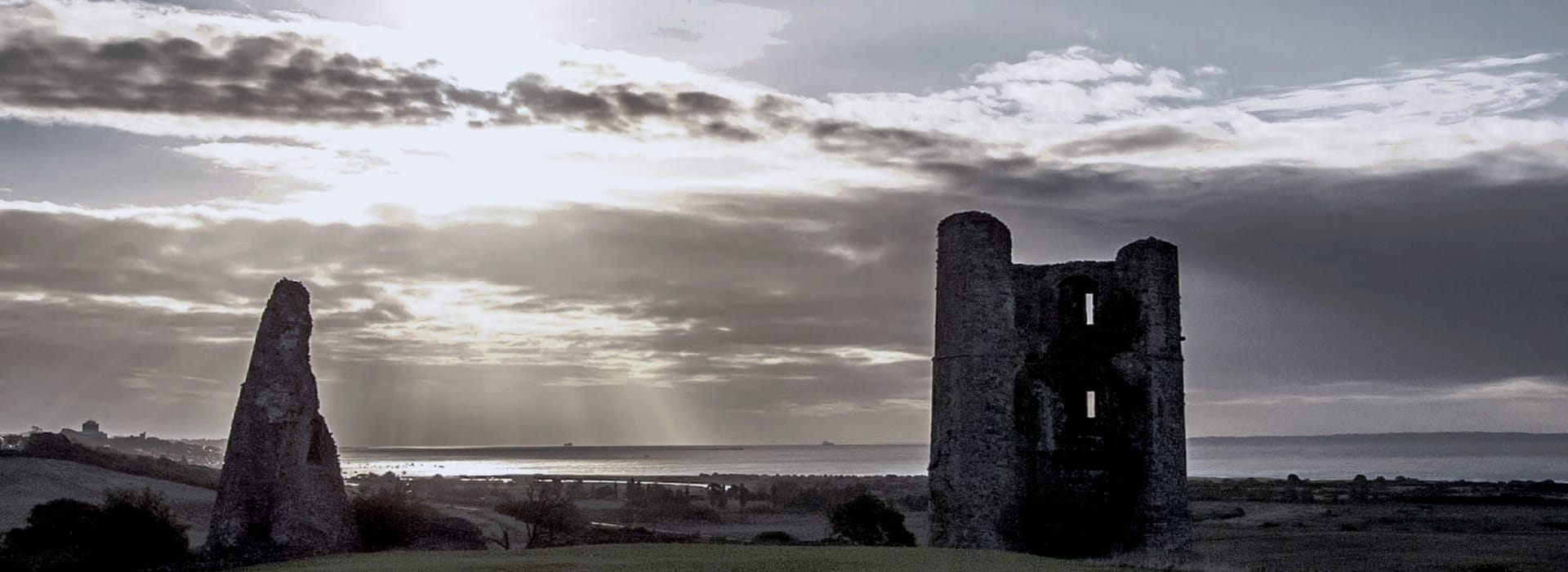 Bespoke Kitchens Rayleigh - Mastercraft Kitchens ruined stone tower and wall silhouetted against dramatic cloudy sky at sunset