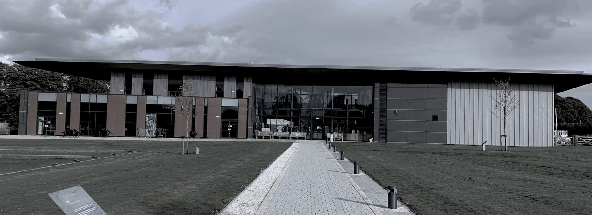 Modern building with flat roof, large glass windows and geometric panel facade