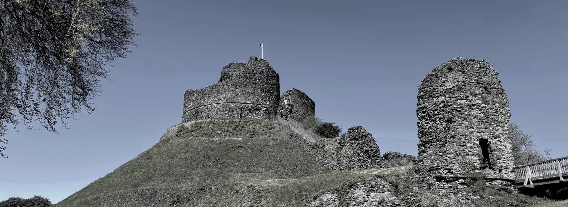 ancient stone castle ruins on grassy hill under clear blue sky