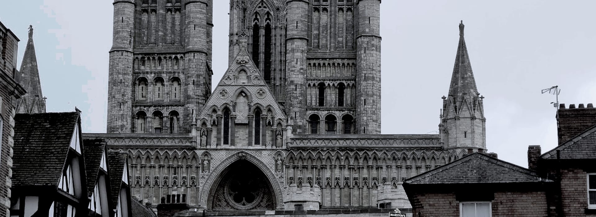 Bespoke Kitchens Lincoln - Mastercraft Kitchens grey stone cathedral with pointed arches and tall towers behind rooftops