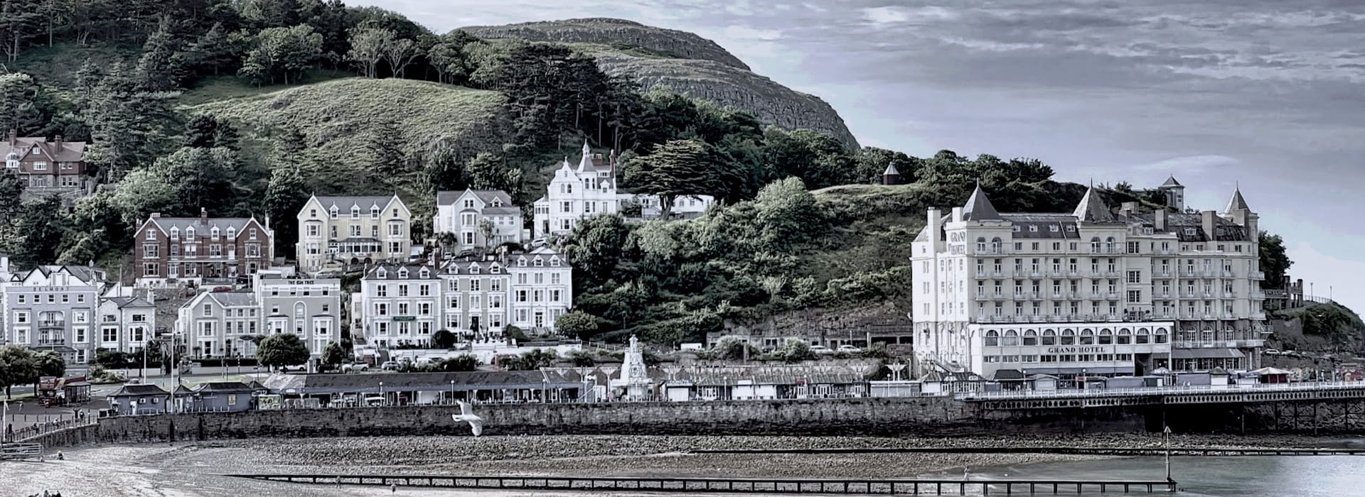 Bespoke Kitchens Llandudno - Mastercraft Kitchens Victorian seaside buildings with pastel facades below a green hillside