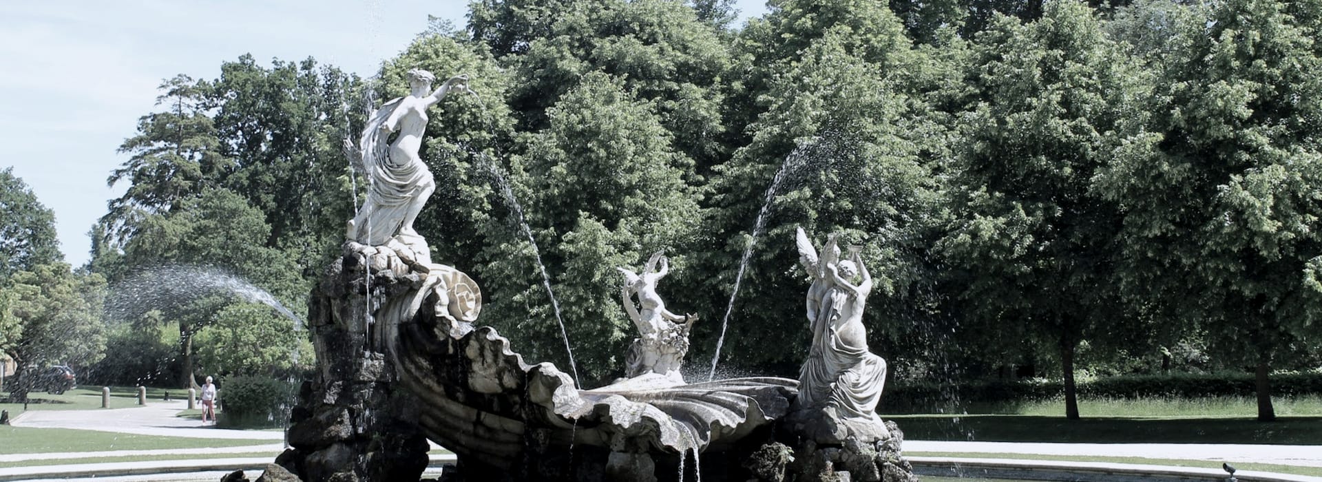 Bespoke Kitchens Marlow - Mastercraft Kitchens ornate stone fountain with classical statues and water jets, green trees behind