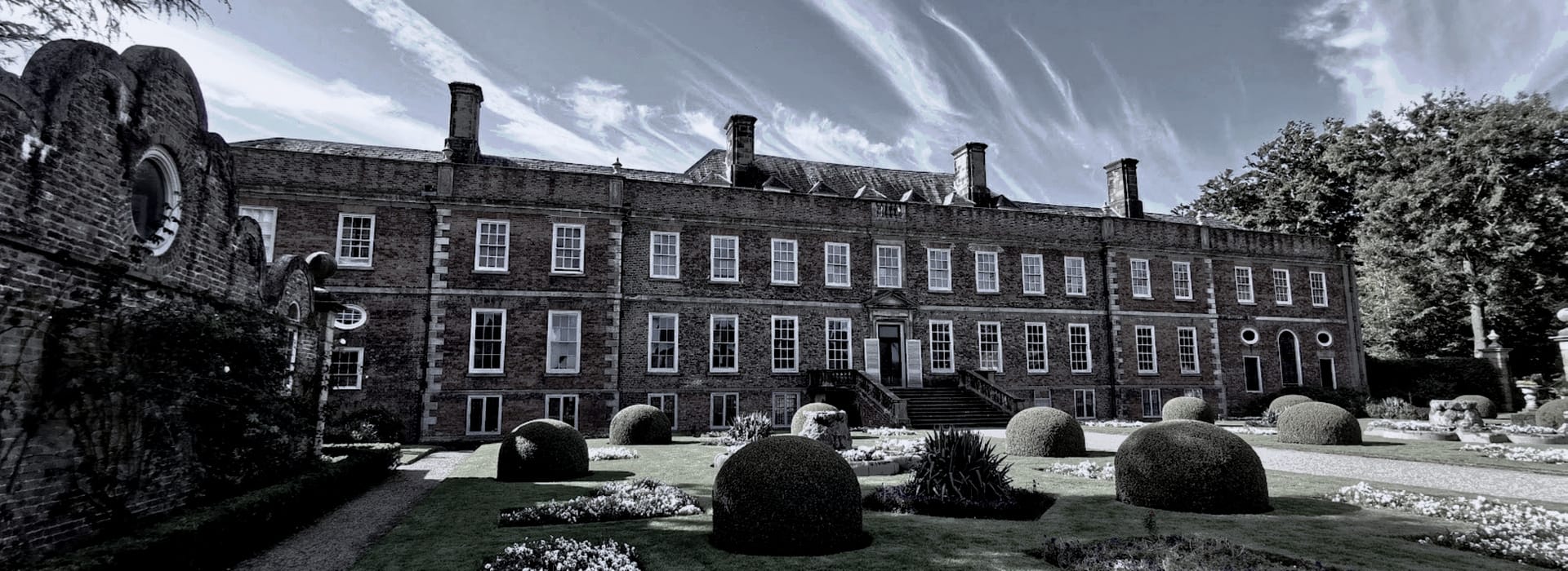 Bespoke Kitchens Bersham - Mastercraft Kitchens historic red-brick mansion with symmetrical windows and sculpted garden hedges
