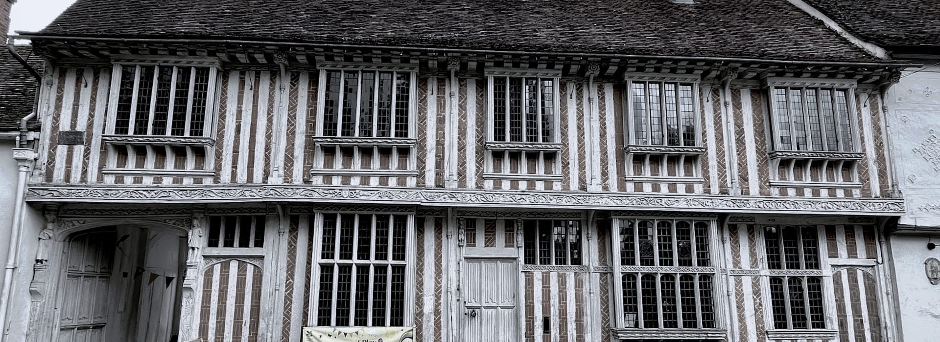 timber-framed building with leaded windows and patterned brickwork