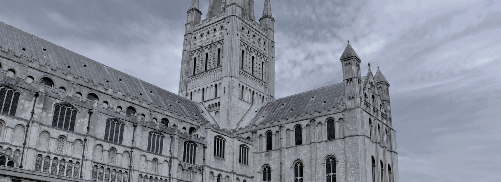 grey stone cathedral with tall central tower and arched windows