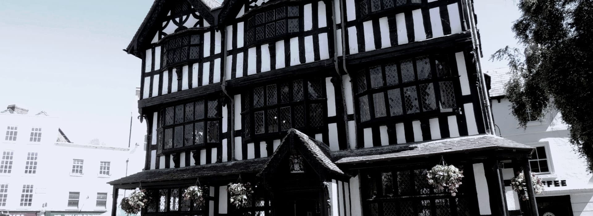 black and white timber-framed building with leaded windows and overhanging upper floors