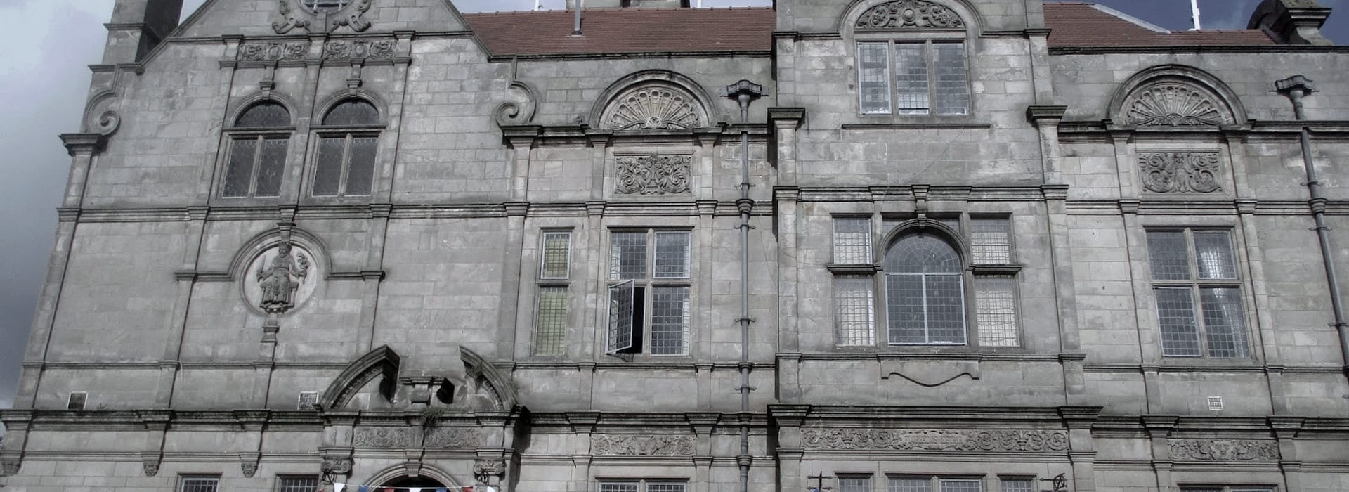 grey stone building with arched windows and decorative carvings