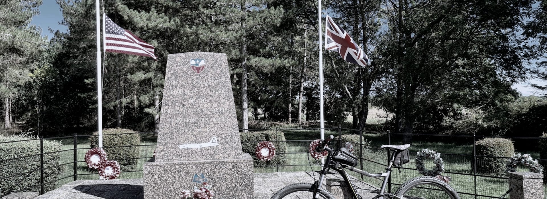 Bespoke Kitchens Underwood - Mastercraft Kitchens granite memorial with wreaths, US and UK flags, bicycle in foreground