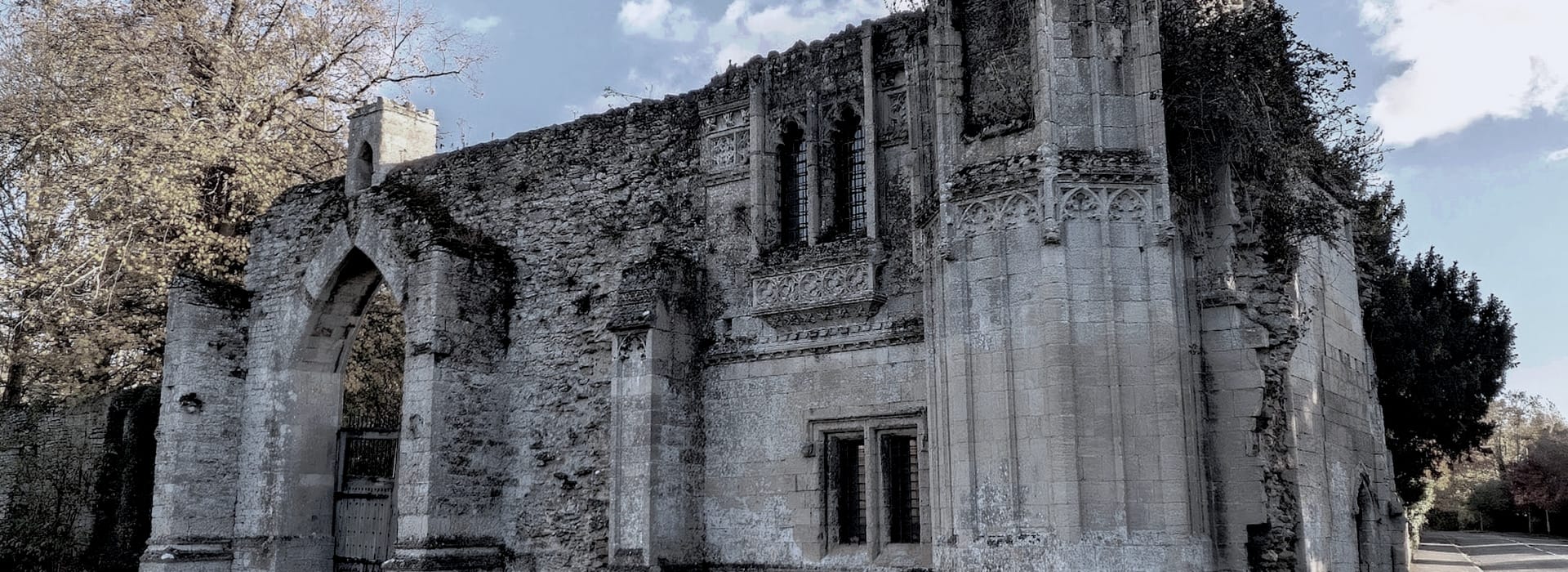 weathered stone ruins with arched doorway and ornate gothic window details