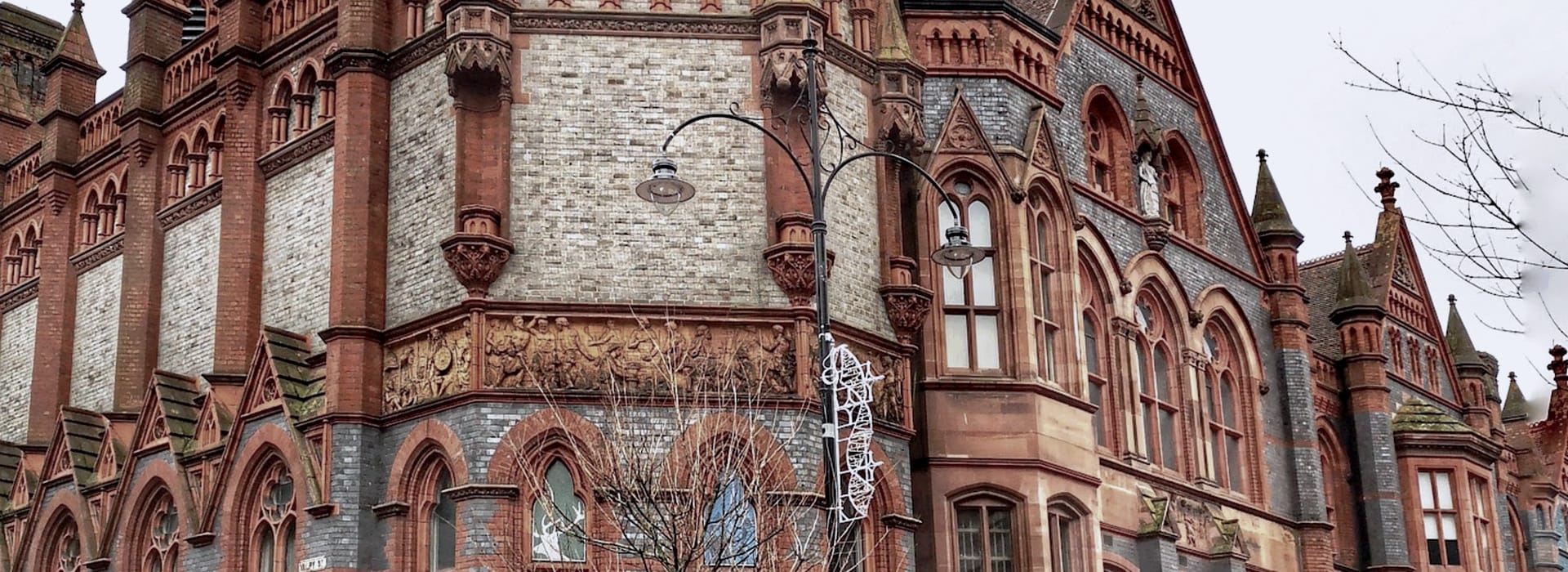 Victorian red brick building with ornate arched windows and sculpted frieze