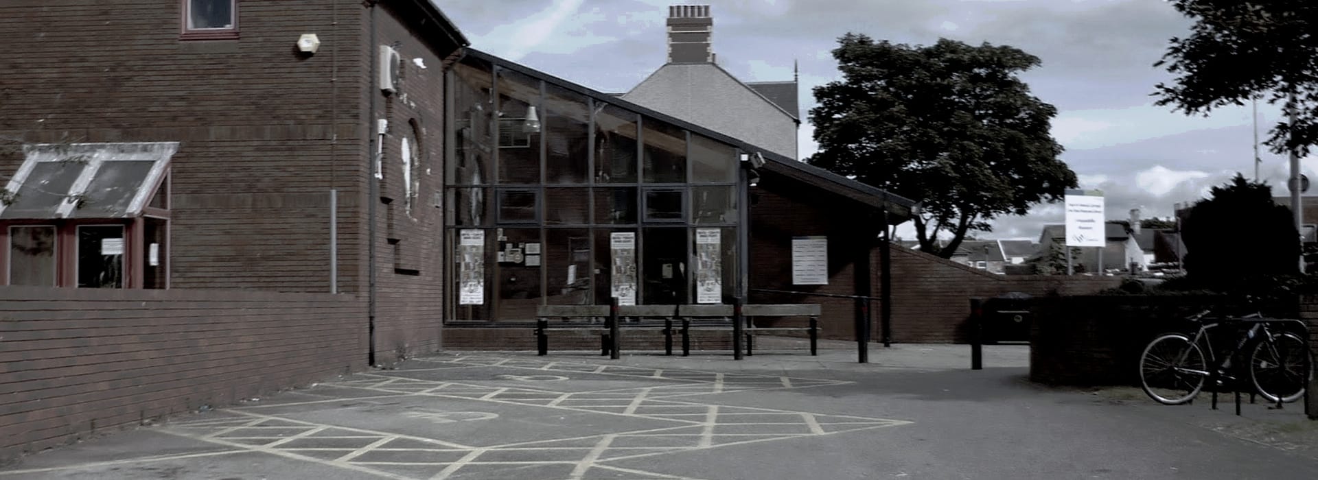 Bespoke Kitchens Rhyl - Mastercraft Kitchens brick building with large glass entrance and yellow disabled parking lines