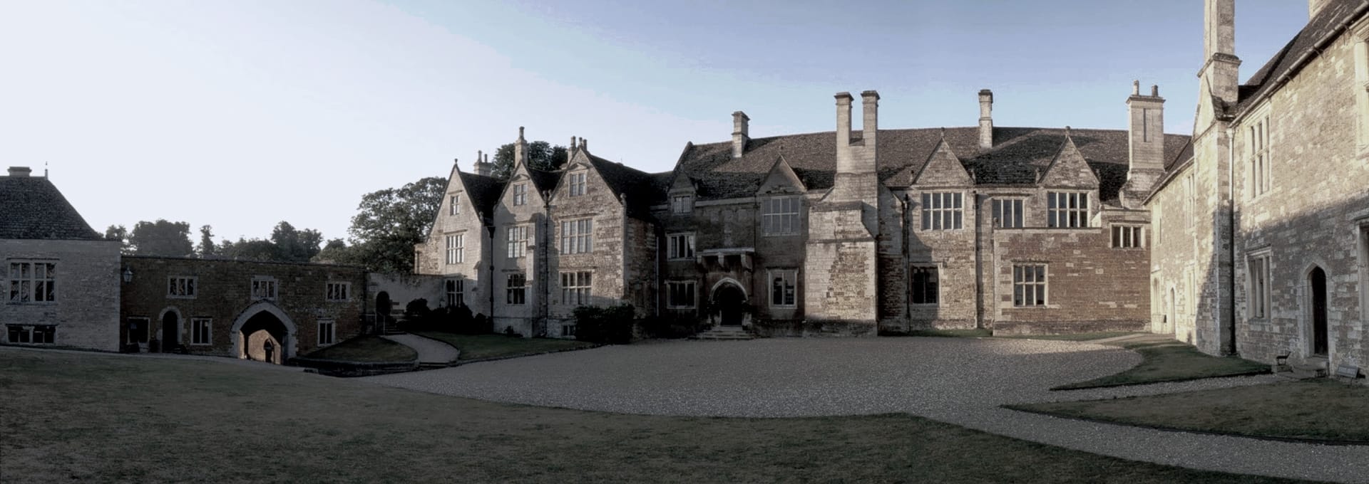 historic stone manor house with tall chimneys and arched entrance