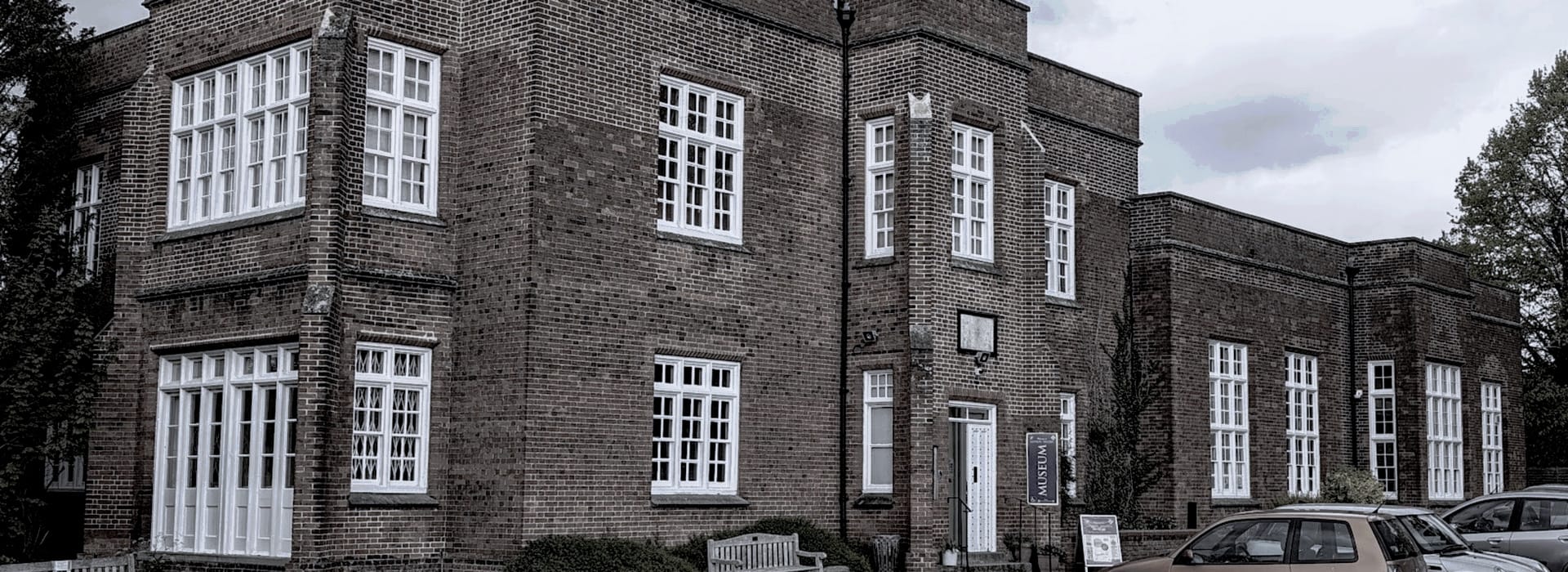 Red brick building with large white-framed windows and geometric layout