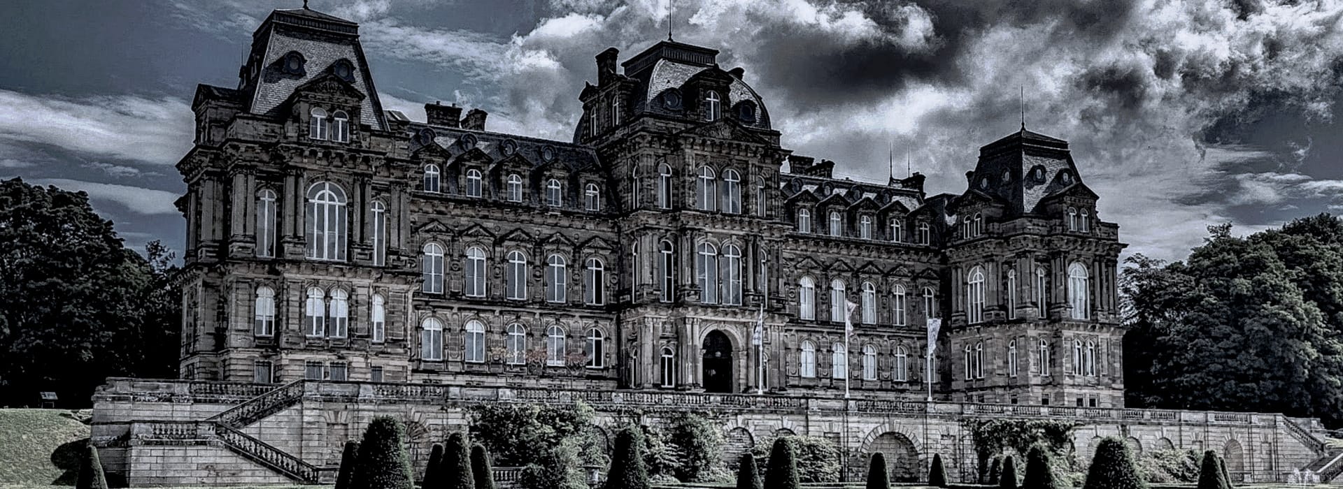 grand historic building with ornate stonework under dramatic cloudy sky