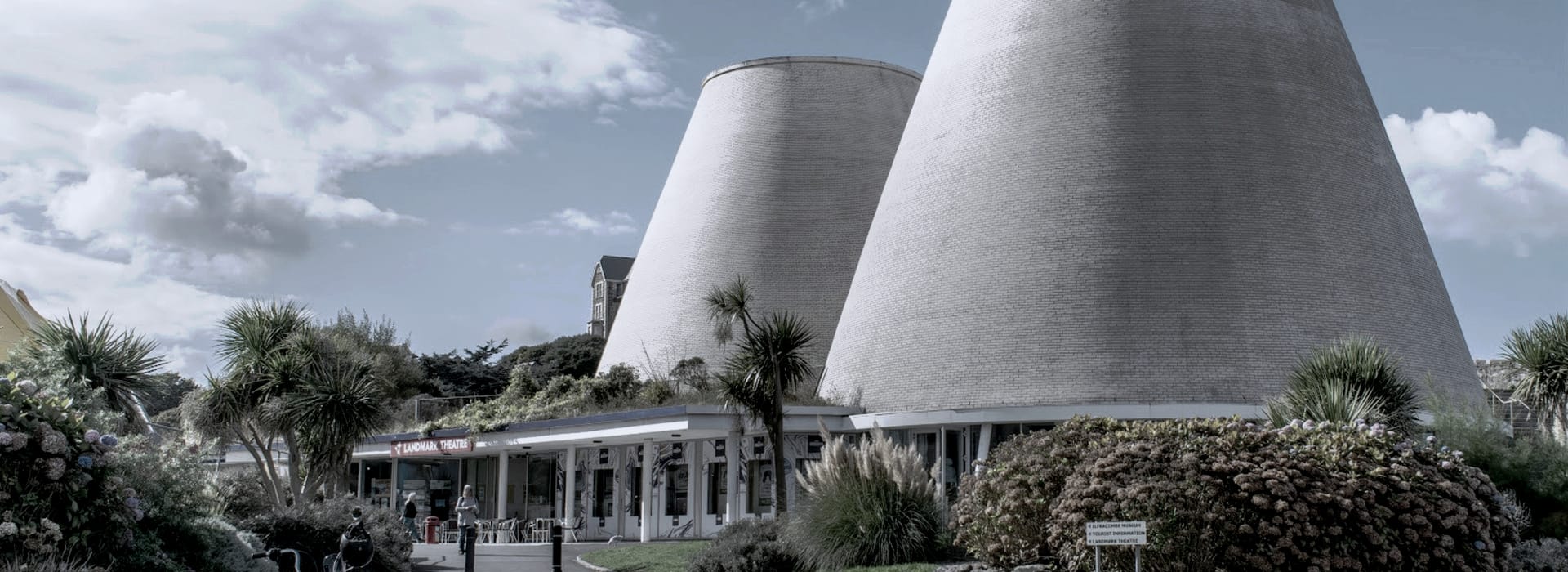 Bespoke Kitchens Ilfracombe - Mastercraft Kitchens two large conical grey brick structures with surrounding greenery and cloudy sky