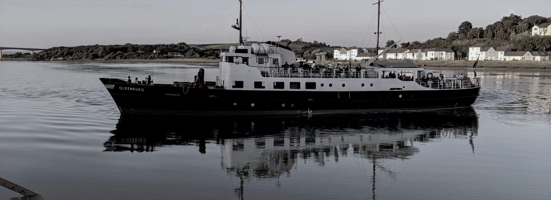 Bespoke Kitchens Bideford - Mastercraft Kitchens black and white passenger ferry Oldenburg on calm water with houses in background