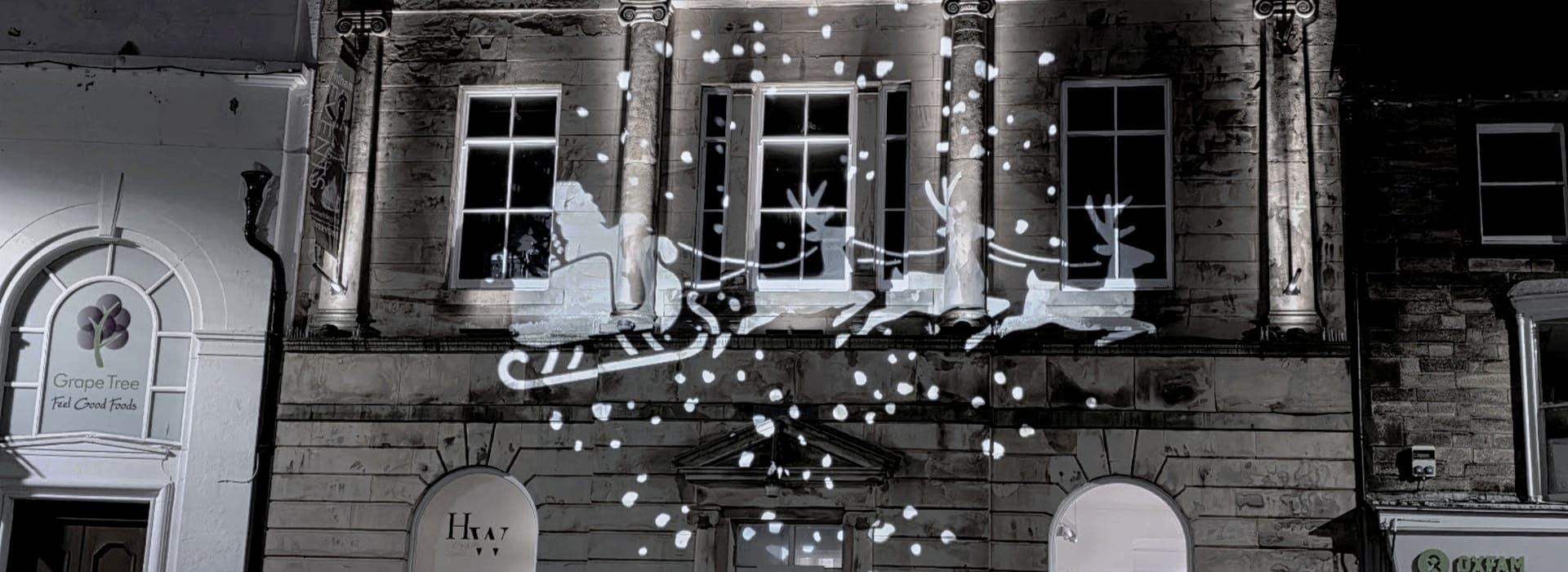 Bespoke Kitchens Witham - Mastercraft Kitchens white silhouette of Santa’s sleigh and reindeer projected onto stone building