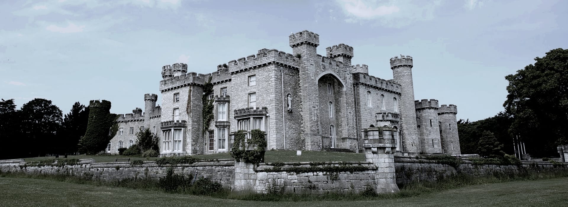 Bespoke Kitchens Bodelwyddan - Mastercraft Kitchens stone castle with crenellated towers and arched windows surrounded by green lawn