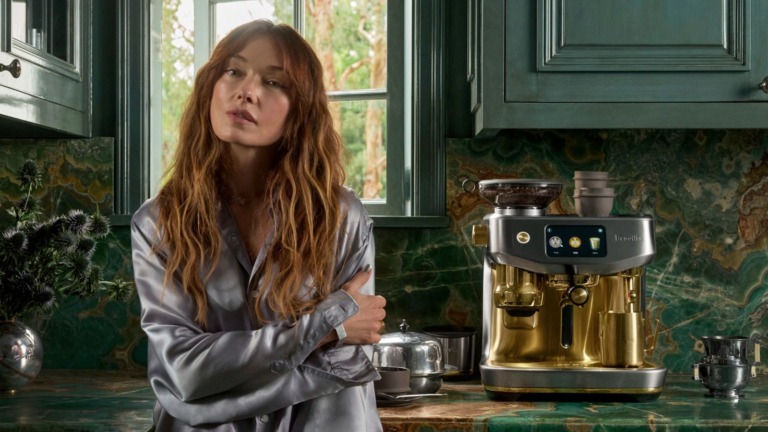 Dark green panelled cabinets with a green marble worktop and a matching full-height splashback