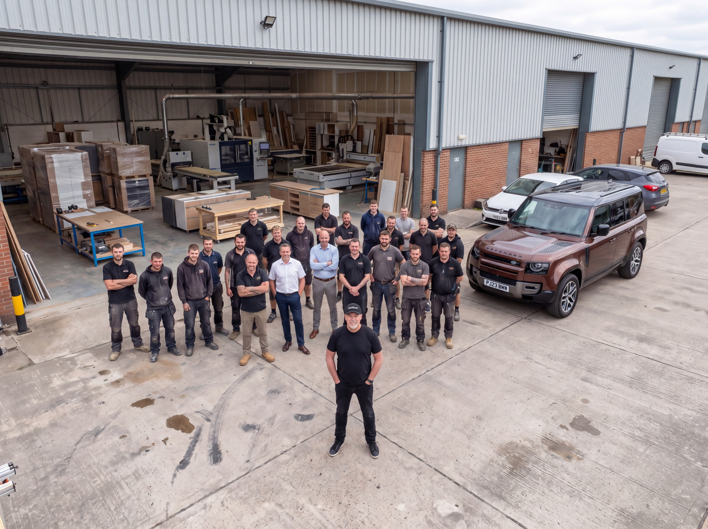 mastercraft kitchens factory 4_3 The company team posing for a group photo outside their workshop, with machinery visible through open doors